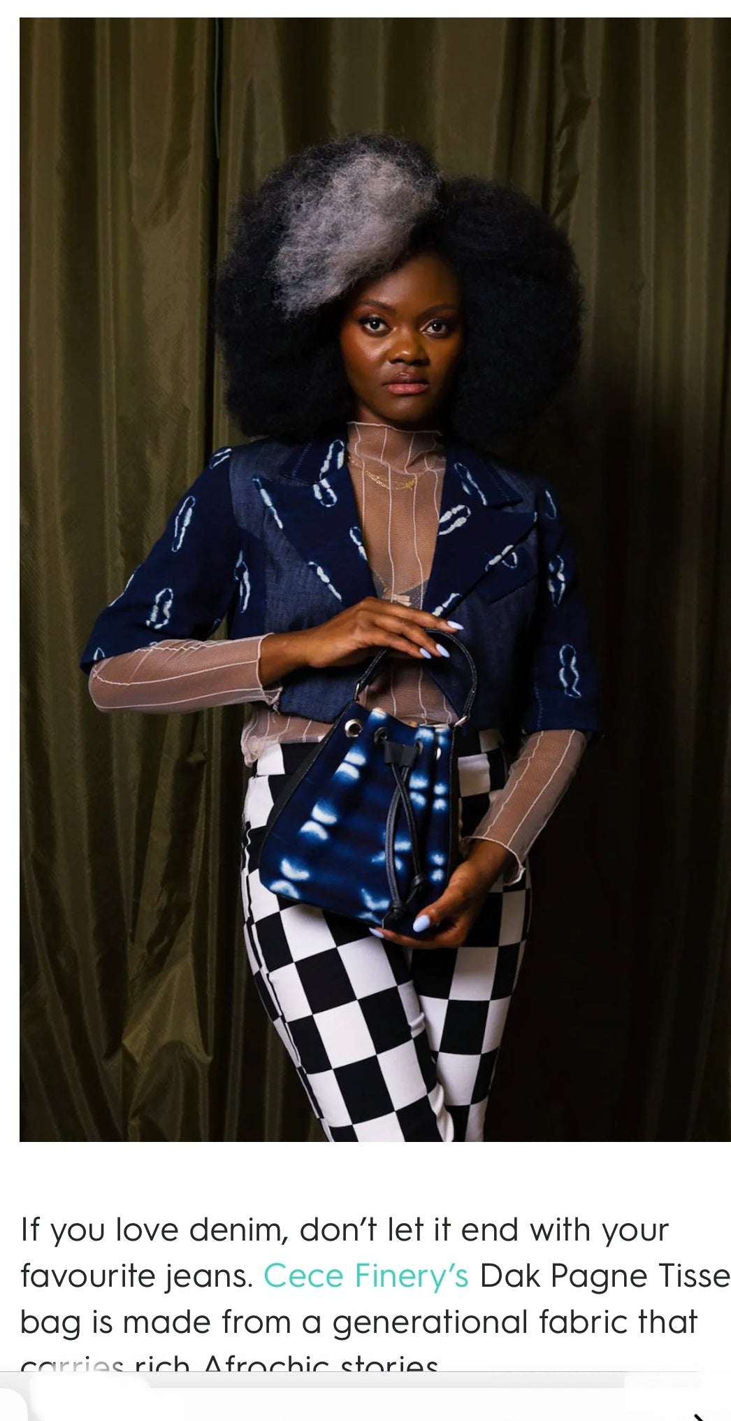 Woman wearing a patterned top and checkered pants against a dark curtain background